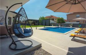 a swing with an umbrella next to a swimming pool at Villa D&V in Veli Vrh