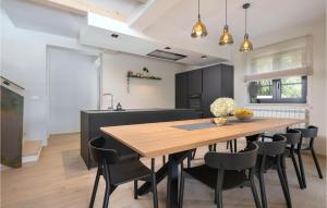 a kitchen and dining room with a wooden table and chairs at 5 Bedroom Nice Home In Manjadvorci in Manjadvorci