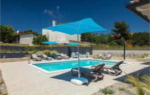 a swimming pool with a blue umbrella and chairs at Villa Dream House in Pula