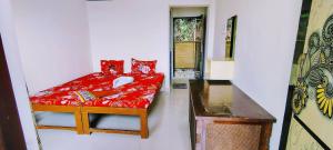 a small bedroom with a red bed in a room at Shree Sai Beach Stay in Arambol