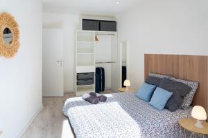 una camera da letto con un letto grande con cuscini blu di La Bulle Paloise, Appartement, hyper-centre a Pau