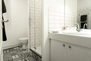 un bagno bianco con lavandino e WC di La Bulle Paloise, Appartement, hyper-centre a Pau Altre 14 foto