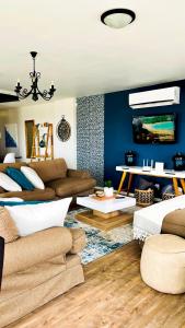 sala de estar con paredes azules y sofá en Izmir Penthouse, en Swakopmund