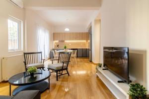 a living room with a large television and a table at Koukaki Lux Apartment in Athens