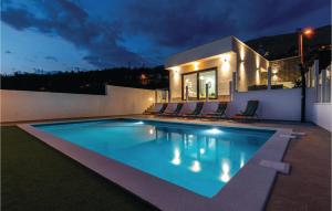 a swimming pool in the backyard of a house at night at Lovely Home In Srinjine in Srinjine