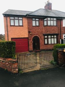 una casa de ladrillo rojo con garaje rojo en Newtons Lodge, en Nottingham
