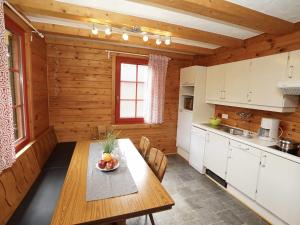 a kitchen with a wooden table in a cabin at Harfenmühle Camping in Mörschied
