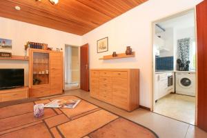 cocina con armarios de madera, lavadora y secadora en Bungalow-Cara, en Norddeich