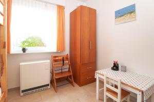 Habitación con mesa, silla y armario. en Bungalow-Cara, en Norddeich