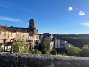 eine Gruppe von Gebäuden auf einem Hügel mit einem Turm in der Unterkunft Nichoir des gorges in Montolieu