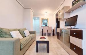 a living room with a couch and a flat screen tv at Cozy Apartment In Oropesa Del Mar in Oropesa del Mar