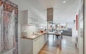 cocina con armarios blancos y suelo de madera en Passatvilla - Apartment 3, en Travemünde