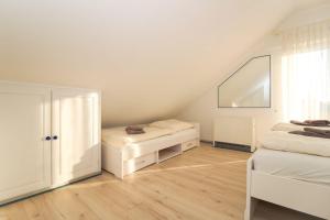 Una habitación blanca con dos camas y una ventana. en MeerSinn, en Norddeich