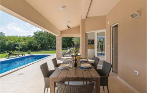 comedor con mesa, sillas y piscina en Stunning Apartment In Labin With Sauna, en Labin