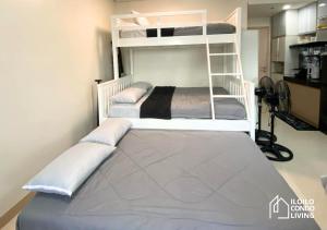 a bedroom with two bunk beds and a ladder at Family Unit B with balcony - Iloilo Condo Living in Iloilo City