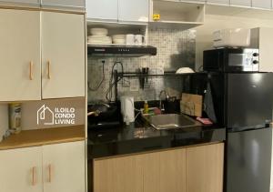 a kitchen with a stainless steel refrigerator and a sink at Family Unit B with balcony - Iloilo Condo Living in Iloilo City
