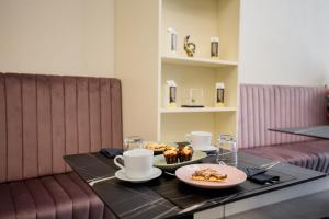 a table with two cups and a plate of food on it at MAZZINI PALACE in Misterbianco
