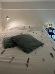 - un lit avec un oreiller vert et des oiseaux dans l'établissement Clemençon by BLOSS, à Gand 7 autres photos