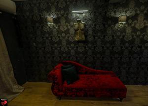 a red couch in a room with a wall at Spank IT in Tondela