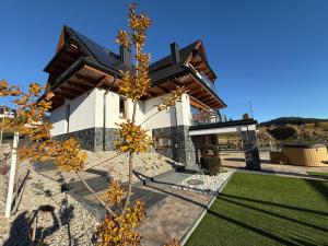 a house with a tree in front of it at Villa Lawendowy Prestige- balia, sauna, bilard in Czarna Góra