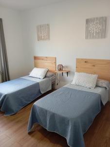 two beds sitting next to each other in a room at Villa Turística Miguel in Pulianas