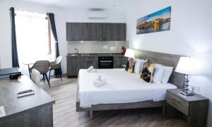 a bedroom with a large bed and a kitchen at Napoli Suites Studios Aparthotel in St. Julianʼs
