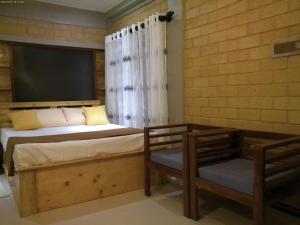 Un dormitorio con una cama y una silla y una ventana. en Liyans Eco Villa, en Habaraduwa Central