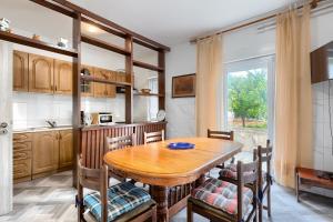 kuchnia z drewnianym stołem i krzesłami w obiekcie Apartments Erla w mieście Banjole