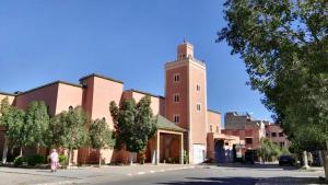 a large brick building with a clock tower at Riad SARSAR airport in Marrakesh