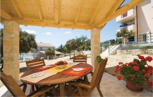 una mesa de madera y sillas bajo una pérgola de madera en Apartment Pavlinka Bb Iii, en Posedarje
