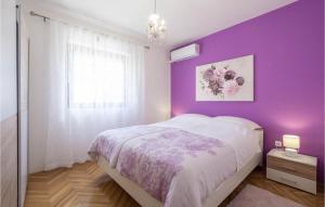 ein lila Schlafzimmer mit einem Bett und einer lila Wand in der Unterkunft Awesome Home In Zrnovnica With Kitchen in Žrnovnica + 23 Fotos
