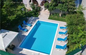 einen Blick über einen Pool mit blauen Stühlen in der Unterkunft Awesome Home In Zrnovnica With Kitchen in Žrnovnica