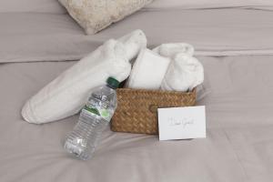 een mand met handdoeken en een fles water op een bed bij NK Venice Apartment in Venetië +11 foto's
