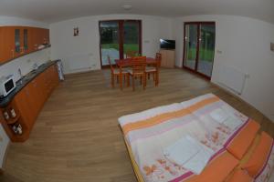 a living room with a bed and a dining room at Penzion U Blatce in Nové Hrady