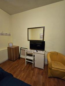 a living room with a tv and a couch at Hotel Liberty in Montecatini Terme
