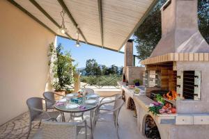 a patio with a table and a fireplace at Villa Olive Grove by Villa Plus in Marathi