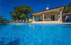 a swimming pool in front of a house at Villa Miana in Orbanići +31 photos