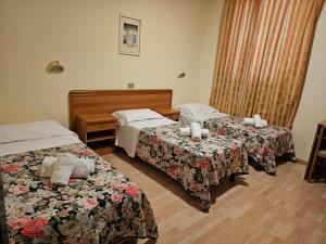 a hotel room with two beds in a room at Hotel Liberty in Montecatini Terme +12 photos