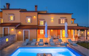 a villa with a swimming pool in front of a house at Nice Home In Hr-52215 Vodnjan in Vodnjan