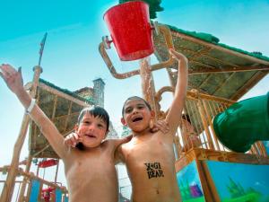 dos chicos están jugando en un tobogán de agua en Yogi Bear's Jellystone Park Camp-Resort Wisconsin Dells en Wisconsin Dells