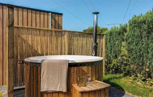 a hot tub on a wooden fence with two wine glasses at 2 Bedroom Cozy Home In Heinkenszand in Heinkensand