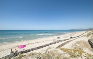 a group of people sitting on a beach with umbrellas at Villa 4 in Stintino