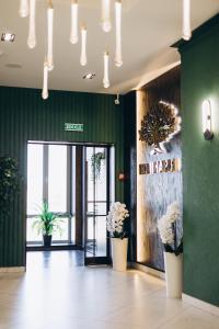 a lobby with green walls and potted plants at Полінарія Козятин in Kozyatyn