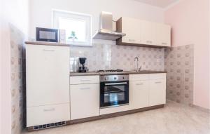 a kitchen with white cabinets and a stove top oven at Three-Bedroom Apartment In Slivnica in Slivnica