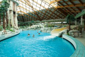 a pool in a resort with people in the water at Hiška Orel Terme Čatež in Čatež ob Savi