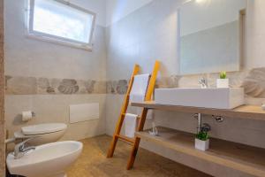 トッレ・ラピッロにあるVilla Perla Marinaの白い洗面台とトイレのあるバスルーム