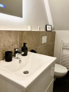 a bathroom with a white sink and a toilet at Airport Business Apartment in Norderstedt