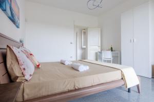 トッレ・ラピッロにあるVilla Perla Marinaのタオルが敷かれた大きなベッドのある寝室
