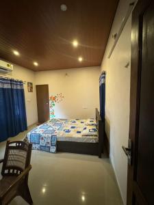 a bedroom with a bed and a chair in it at Zenways Retreat - Poovar in Pūvār