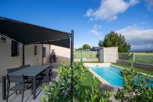 a patio with a table and chairs next to a swimming pool at La casa du lac vue imprenable in Homps
